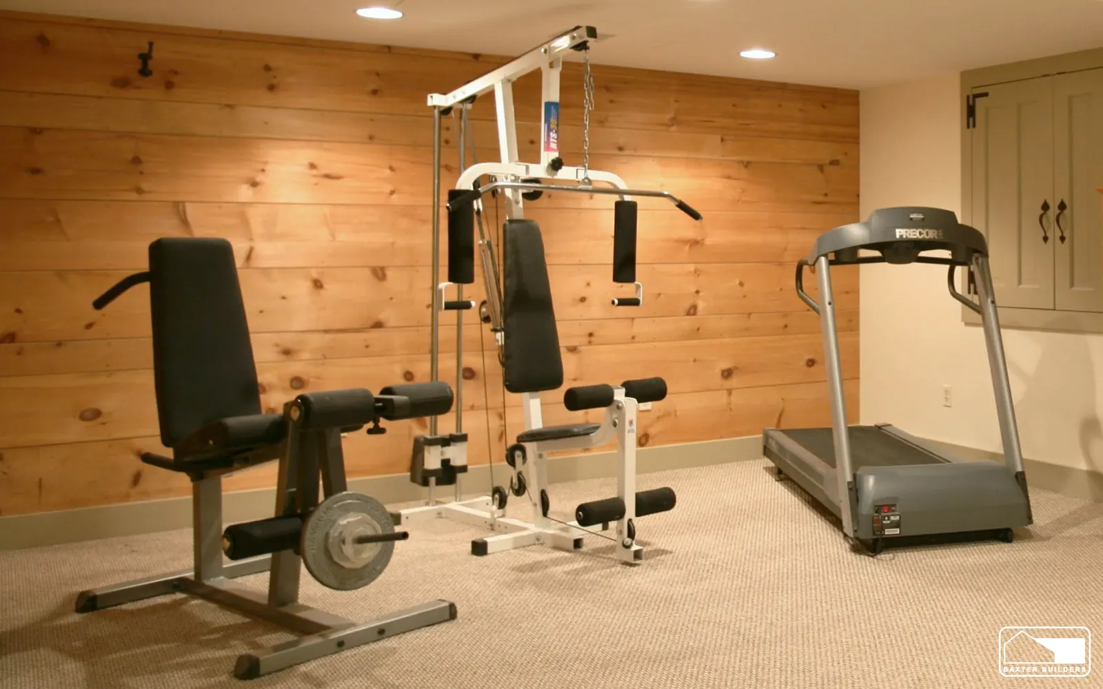 Home gym in a finished basement with knotty pine accent wall