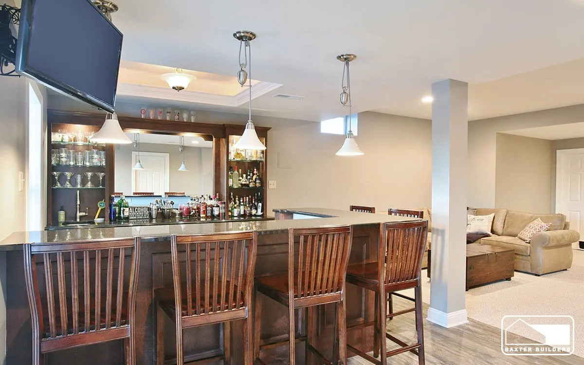 Finished basement with a full wet bar, pendant lights and bar seating