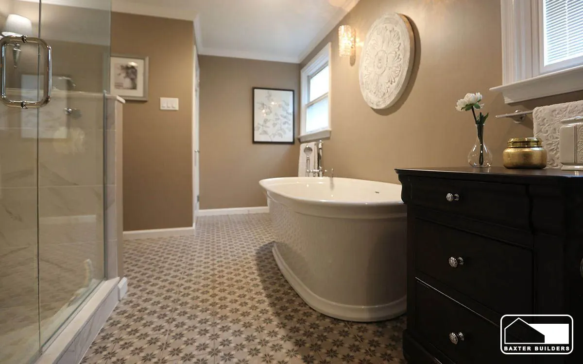Primary bath with freestanding oval tub, glass shower and patterned tile floor