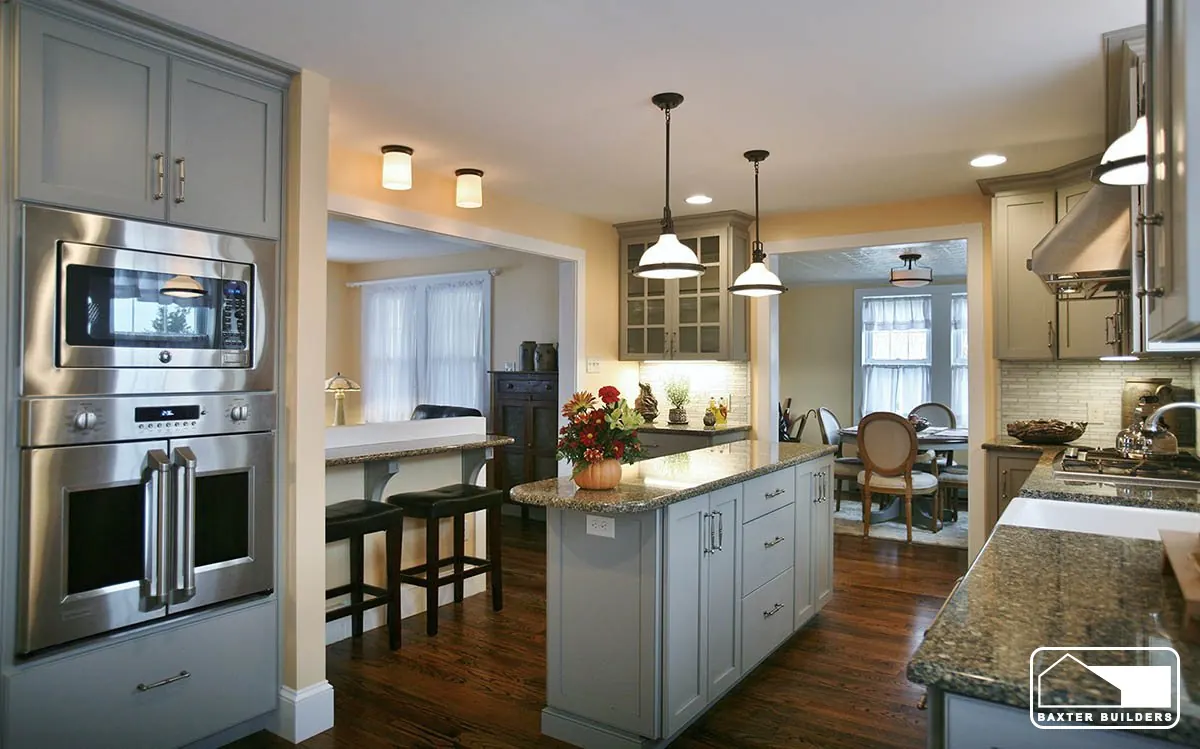 Remodeled kitchen with sage cabinetry, a center island and double wall ovens