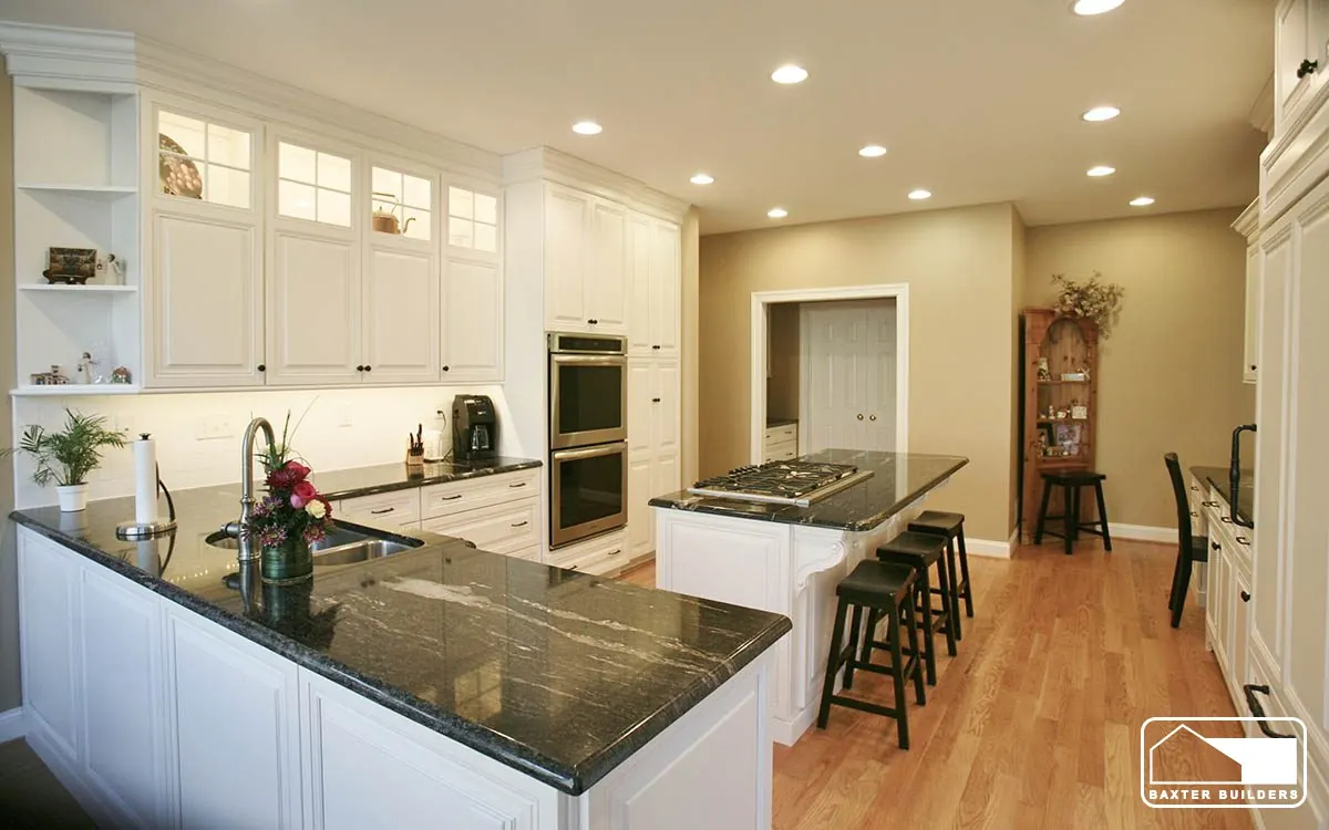 White kitchen with dark granite peninsula and glass-front upper cabinets
